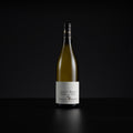 A single bottle of Domaine de Burgan Saint-Bris non-alcoholic white wine, standing upright on a dark reflective surface against a solid black background.