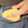 Persona metiendo una tarjeta de bambú con hashtag #yovoyenmetro en bolsillo de jeans