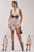 A woman showcases the SORRY NOT SORRY NYLON CINCH MINI DRESS with a wide black belt, black platform boots, hoop earrings, and a black handbag. Two smaller images display her striking similar street-style poses.