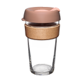 Clear glass reusable cup with a bronze colour lid and wooden sleeve on a white background