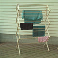 Wood clothes drying rack with multiple tiers holding towels on a wooden deck for laundry and storage organization