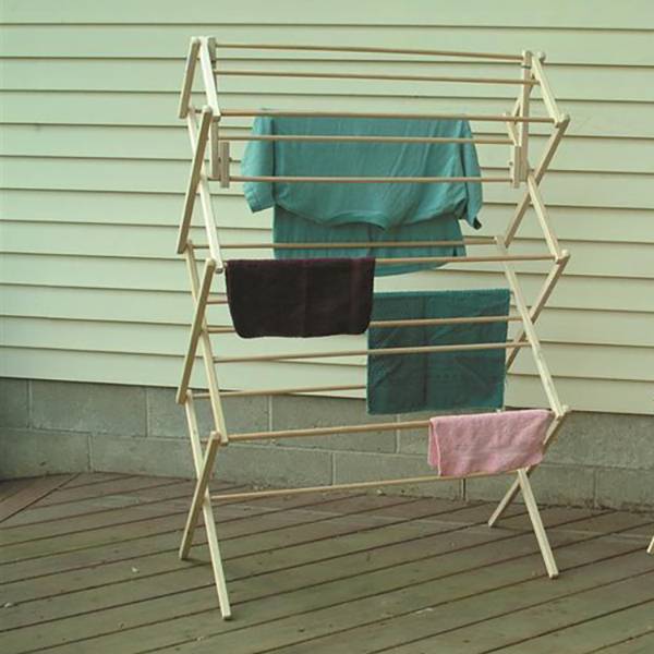 Wood clothes drying rack with multiple tiers holding towels on a wooden deck for laundry and storage organization